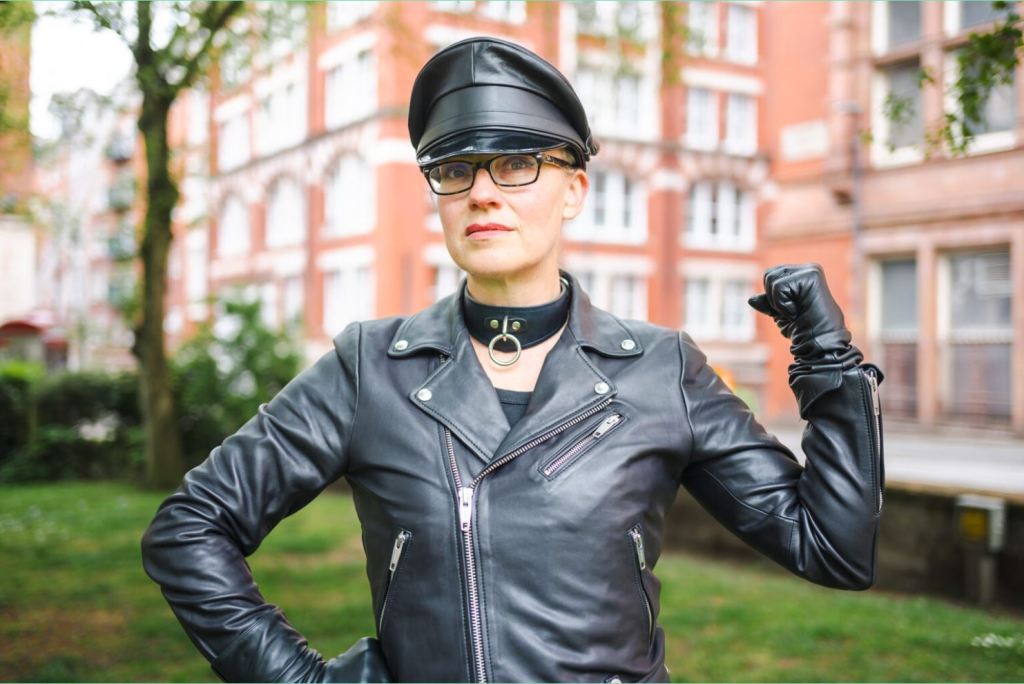 Lynne in leather jacket and cap outside the LGBT Foundation